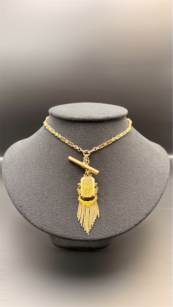 Chaîne de montre Napoléon III en or avec pendentif porte-souvenir et pampilles.