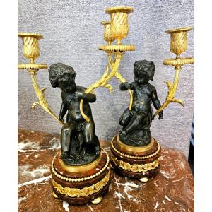Paire de candélabres en bronze doré et patiné aux putti