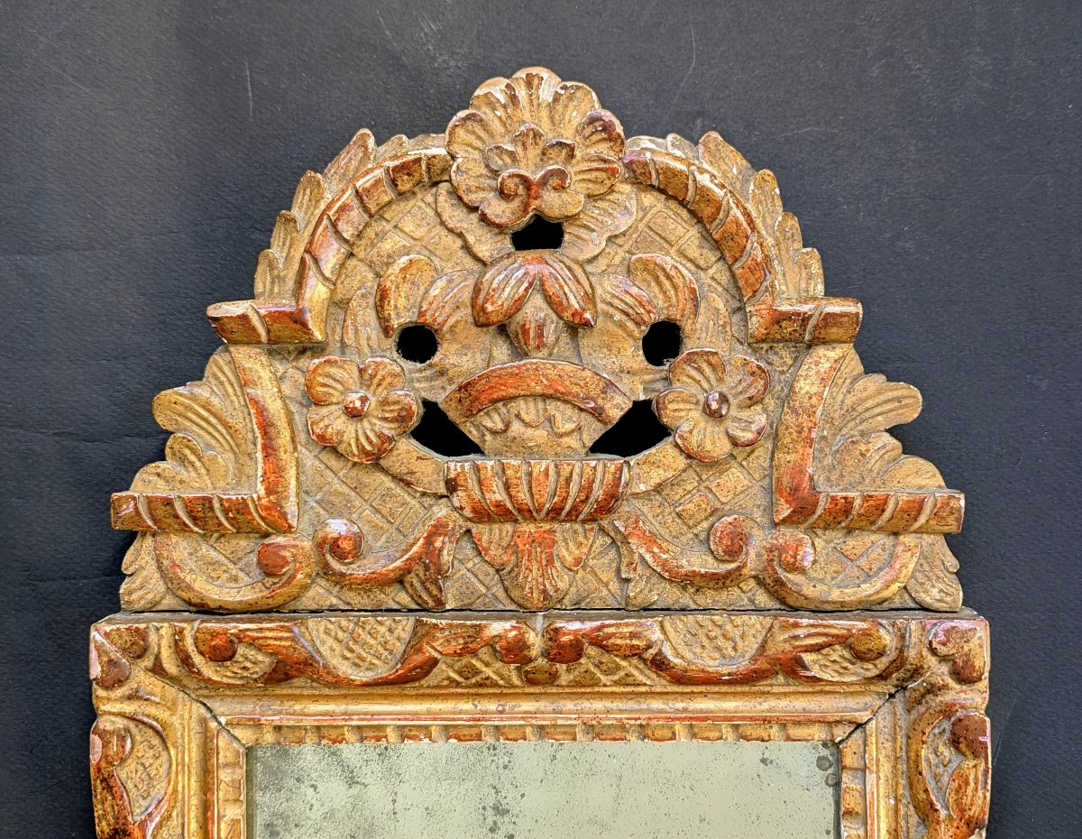 Petit miroir en bois sculpté et doré de style regence.