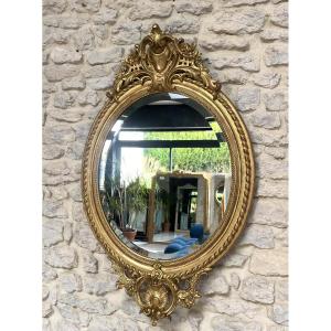 Miroir ancien ovale à frontons et perlé doré à la feuille d’or glace biseautée.