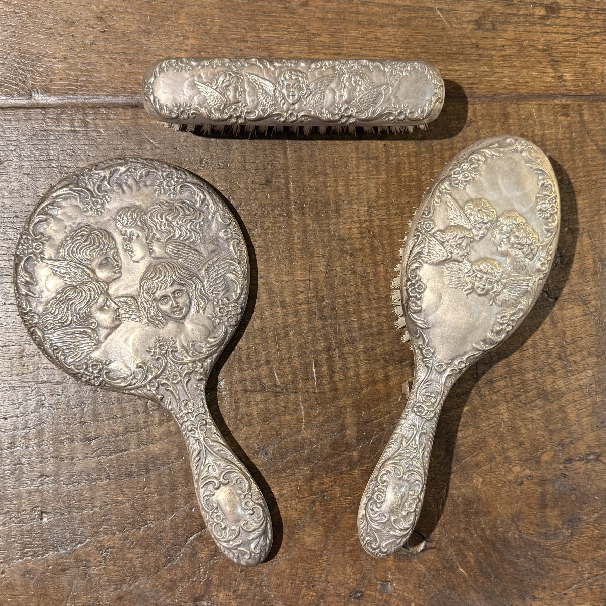 T﻿hree-piece Silver Vanity Set, Consisting Of A Hand Mirror, A Hairbrush And A Small Brush.