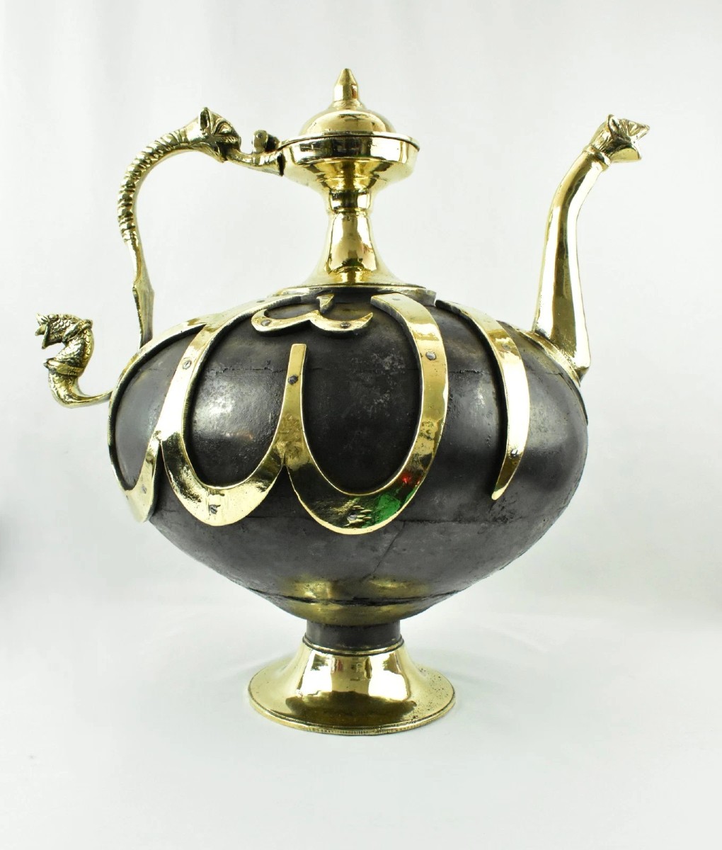 Aiguière islamique lourde et imposante, en bronze bicolore orné, avec anse en forme de dragon.