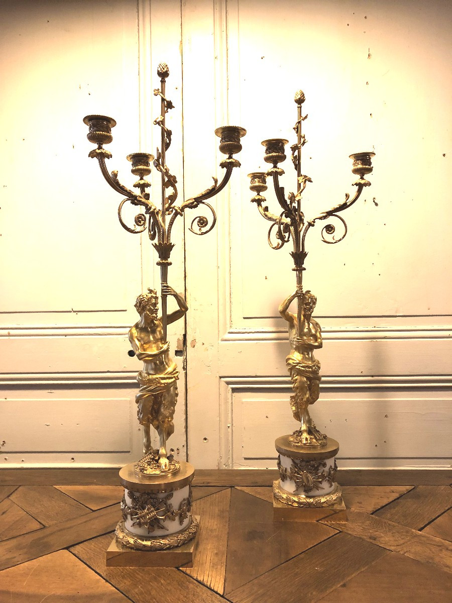 Paire de candélabres aux faunes et attributs de musique en bronze doré et marbre blanc