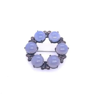 Broche circulaire en agate bleue tachetée taillée en cabochon sertie en argent
