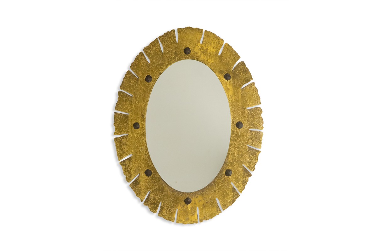 Miroir de forme elliptique en laiton martelé et doré. Années 1950-60.