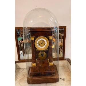 Pendule portique style Empire en acajou et bronze doré sous globe