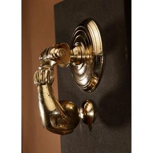 Un heurtoir de porte en bronze de grande taille, représentant une main.