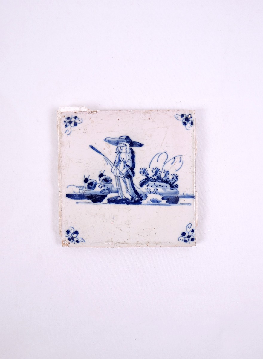 18th-century Delftware Tile Depicting A Peasant Woman With A Stick, Facing Forward