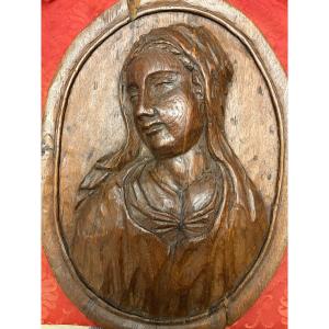 Grand panneau ovale en chêne sculpté. Portrait d’une Sainte Femme, XVII Eme siècle.
