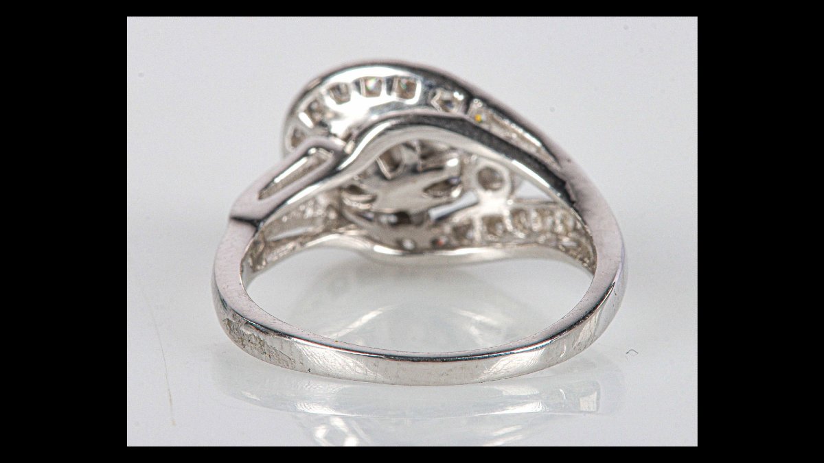 Bague en or gris 585 stylisant une boucle centrée d'un beau cabochon de saphir étoilé-photo-2