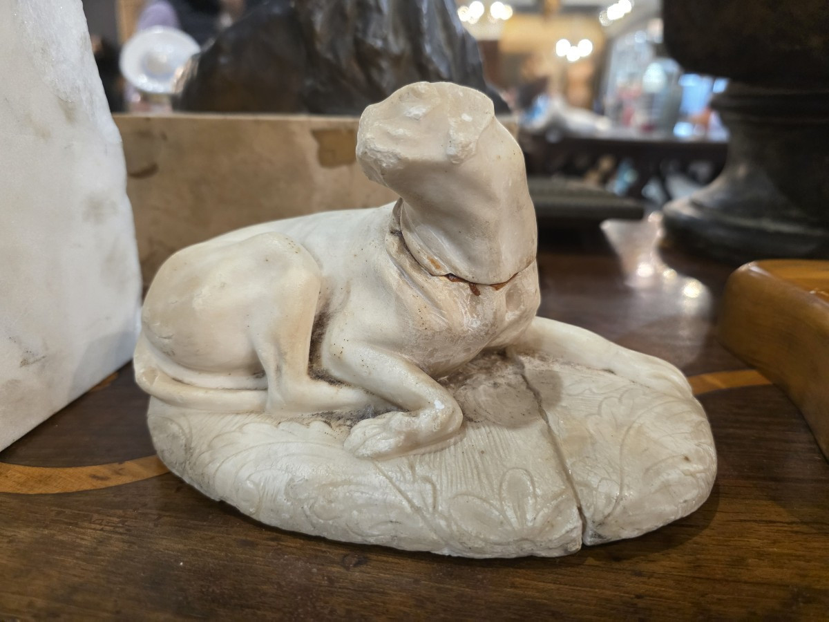 Petite sculpture en marbre représentant un chien couché. Italie, XVIIIe siècle.