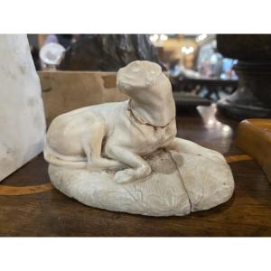 Petite sculpture en marbre représentant un chien couché. Italie, XVIIIe siècle.