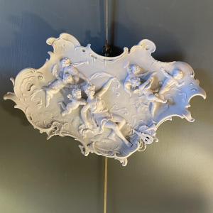 Plat mural en biscuit à décor d'une déesse et de chérubins musiciens 