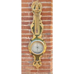 Barometre-Thermomètre en bois laqué vert et doré mouluré et sculpté de cartouches, fleurettes 