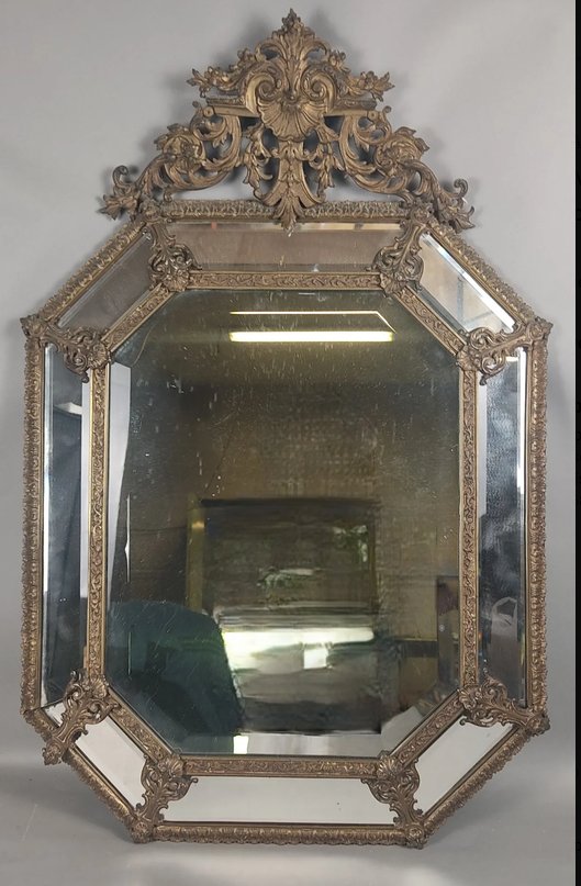 Miroir à parcloses, de forme octogonale, en bronze et laiton ciselé, fronton à décor de rinceau