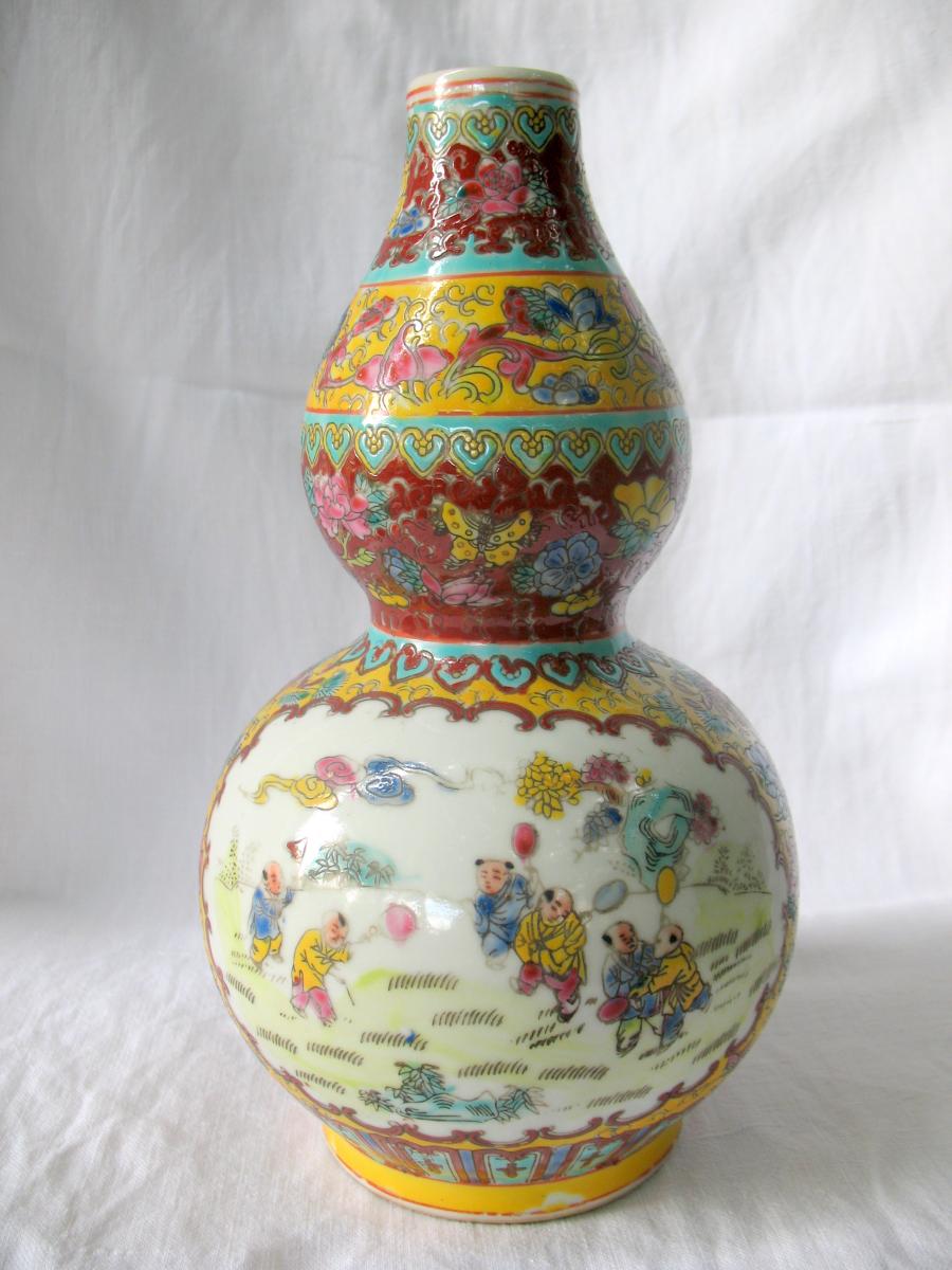 Vase gourde en porcelaine de Chine. Décor d'enfants jouant au ballon. Marque Qianlong