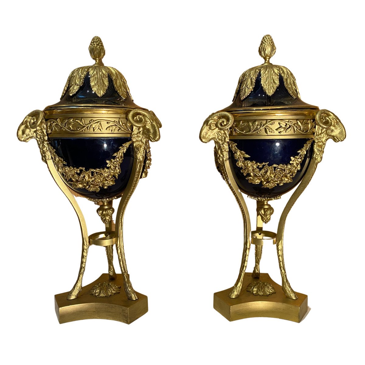 Paire de grandes cassolettes en porcelaine bleu et bronze doré aux décors de têtes de béliers