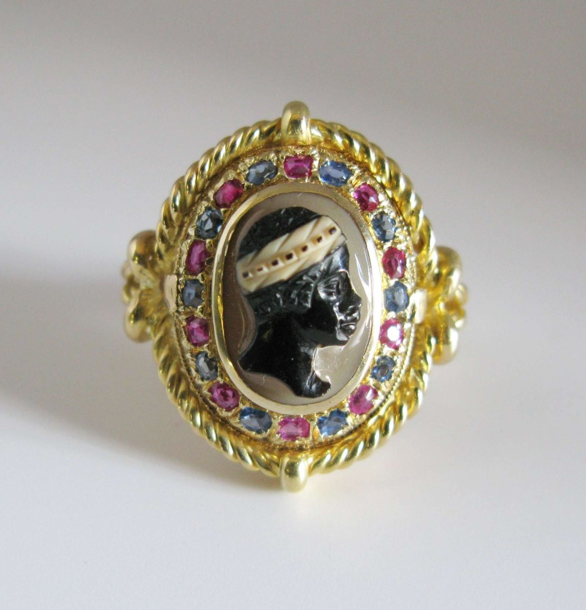 Une bague camée en pierre dure en or 18 carats, rubis et saphirs