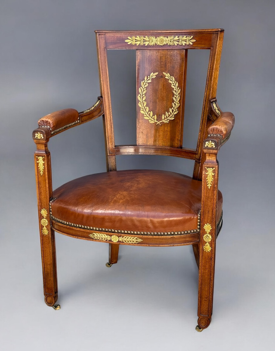 FAUTEUIL DE STYLE EMPIRE EN NOYER ORNÉ DE BRONZE DORÉ RECOUVERT DE CUIR MARRON