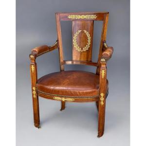 FAUTEUIL DE STYLE EMPIRE EN NOYER ORNÉ DE BRONZE DORÉ RECOUVERT DE CUIR MARRON