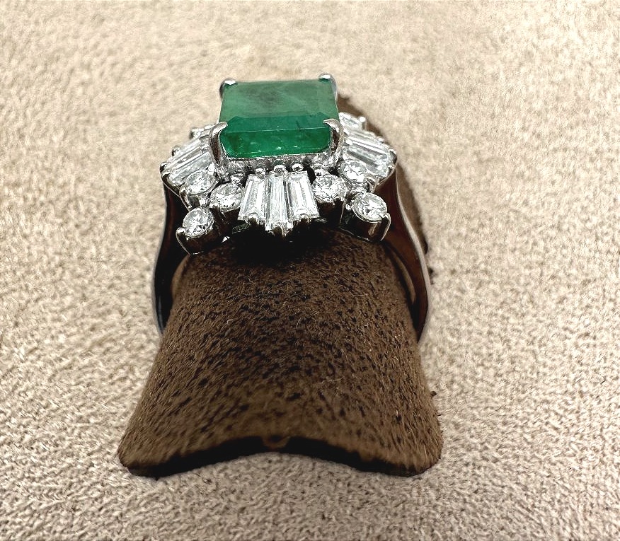 White Gold Ring Set With A Center Emerald And A Diamond Border-photo-1
