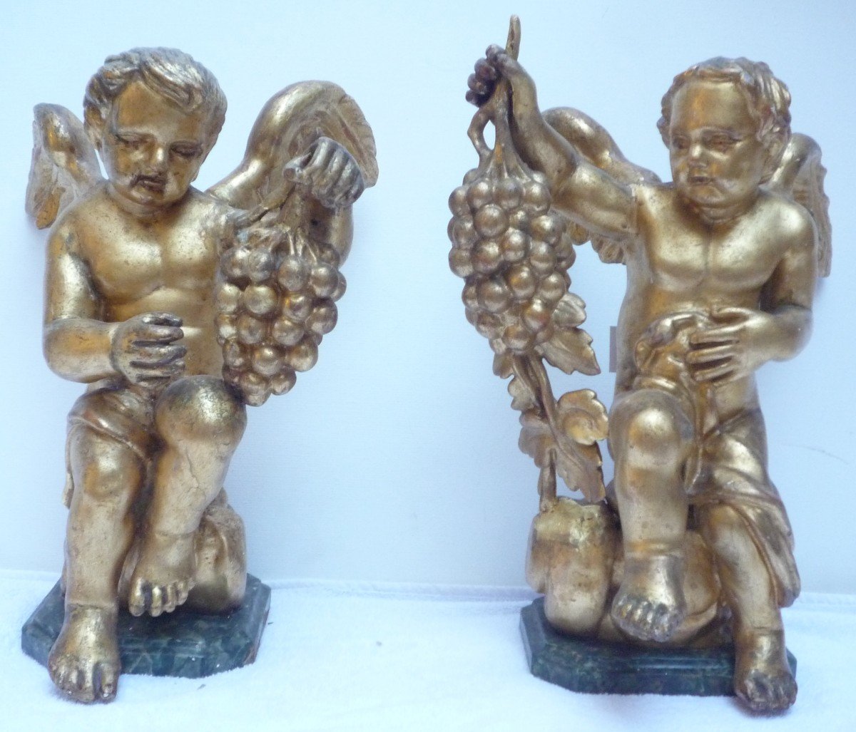Deux anges en bois sculpté et doré sur socle