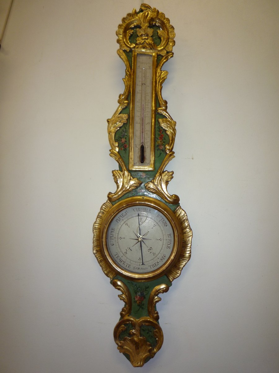 Baromètre Louis XV en bois doré et peint à décor de fleurs.