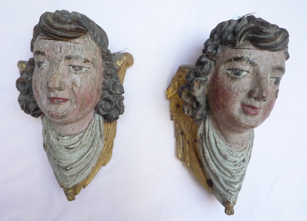 Deux têtes d'anges en bois sculpté peint et doré XVIIème siècle.