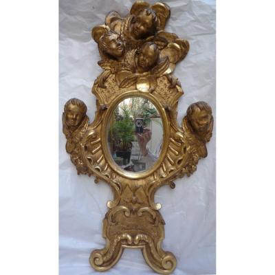 Miroir en bois doré avec cinq têtes d'anges