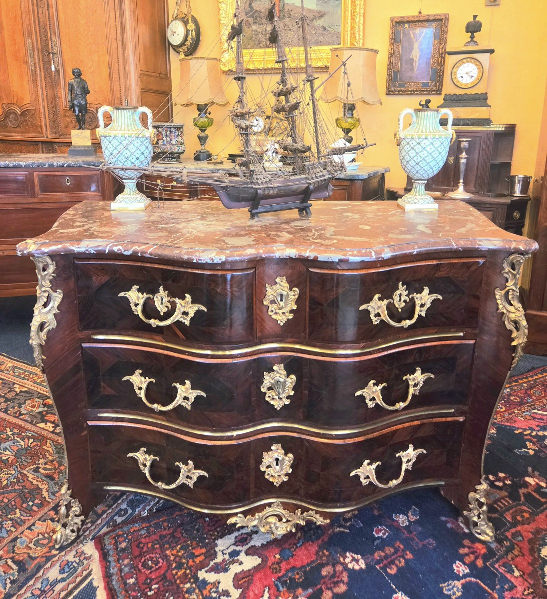 Commode d'époque Régence à façade arbalète en placage d'amarante