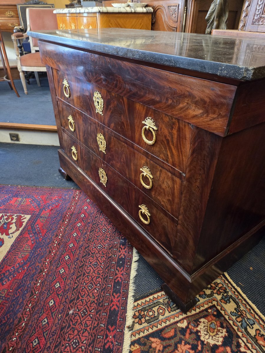 Commode d'époque Restauration en placage d'acajou flammé et à dessus de granit noir .
