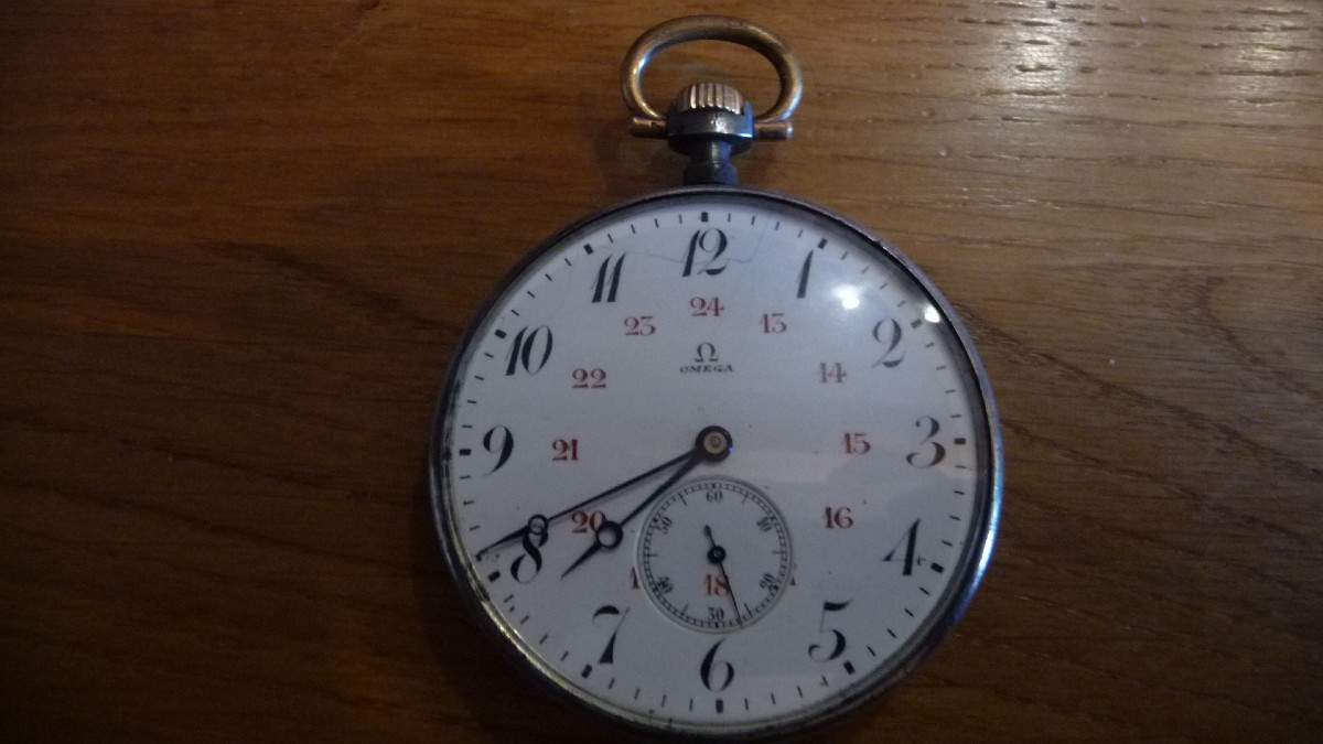 OMEGA: Montre de gousset de marque Oméga en acer bruni et laiton doré, d'époque 1900.