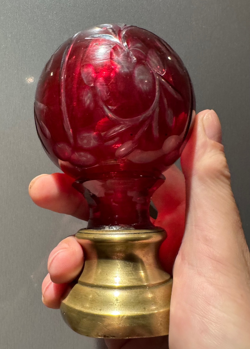 Boule d’escalier en verre rouge rubis à décor floral.