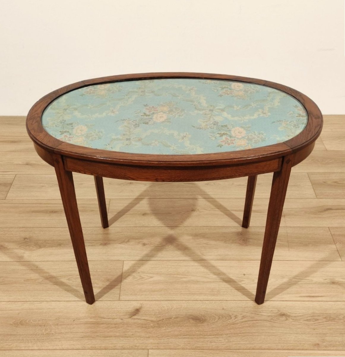 Table ovale en châtaignier recouverte d'un tissu à motifs floraux, Italie, début du XXe siècle