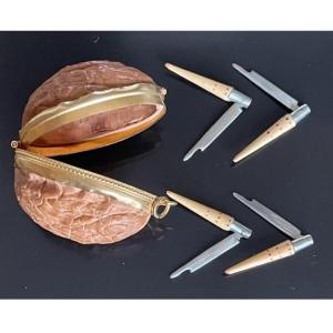 Four Miniature Nontron Clamshell Knives Contained In A Hollowed-out Walnut