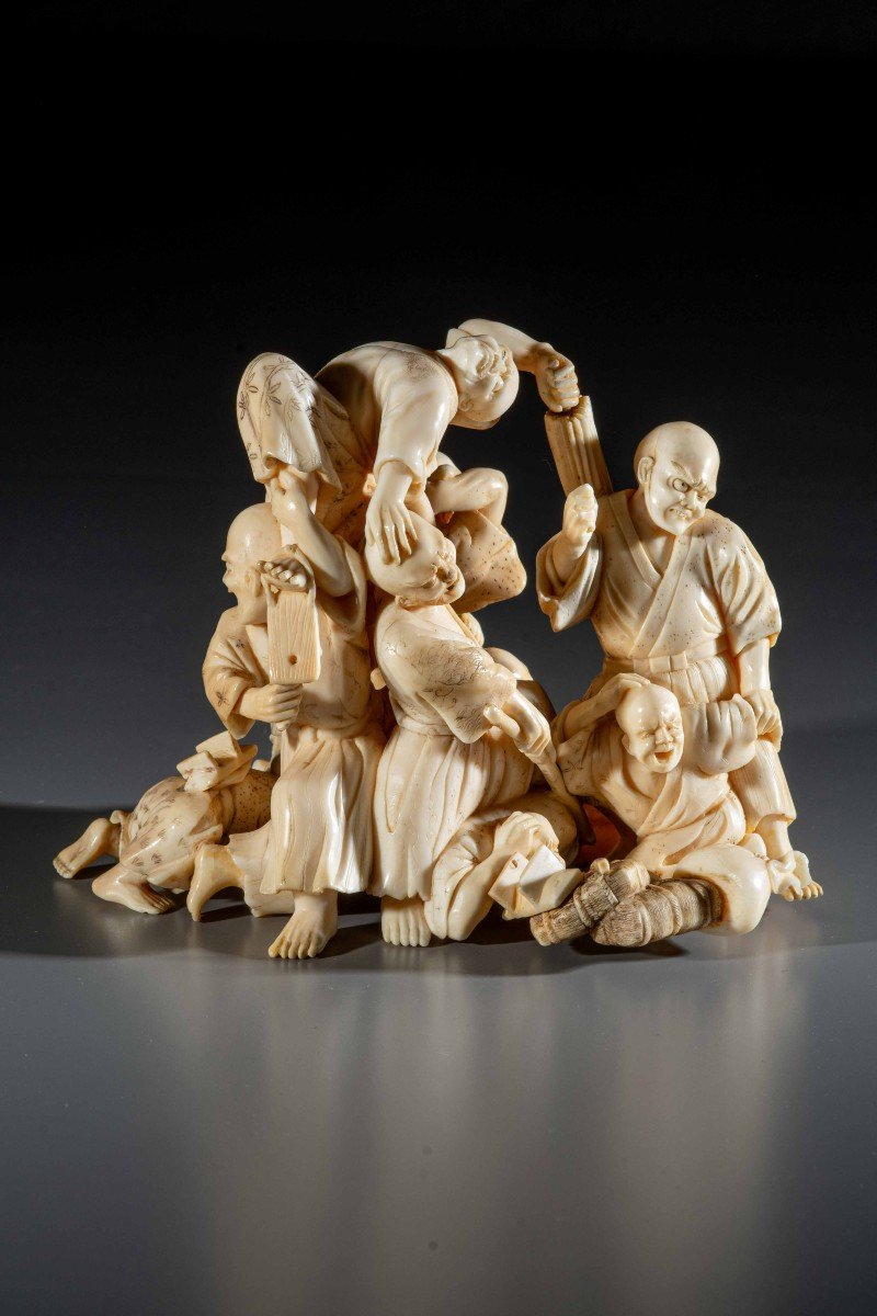 An Ivory Okimono With Blind Travelers Defending Themselves From An Attack
