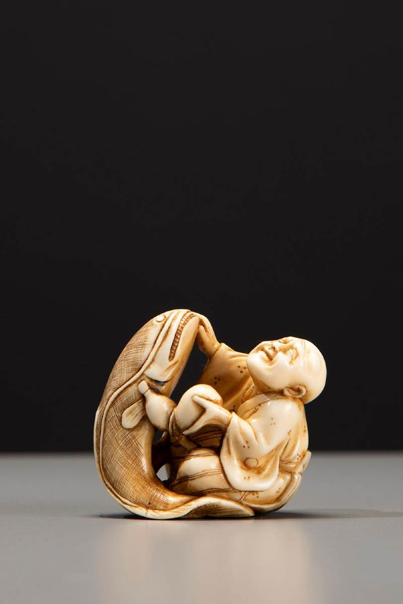 Netsuke en ivoire représentant Kadori Myojin tentant de maîtriser Namazu