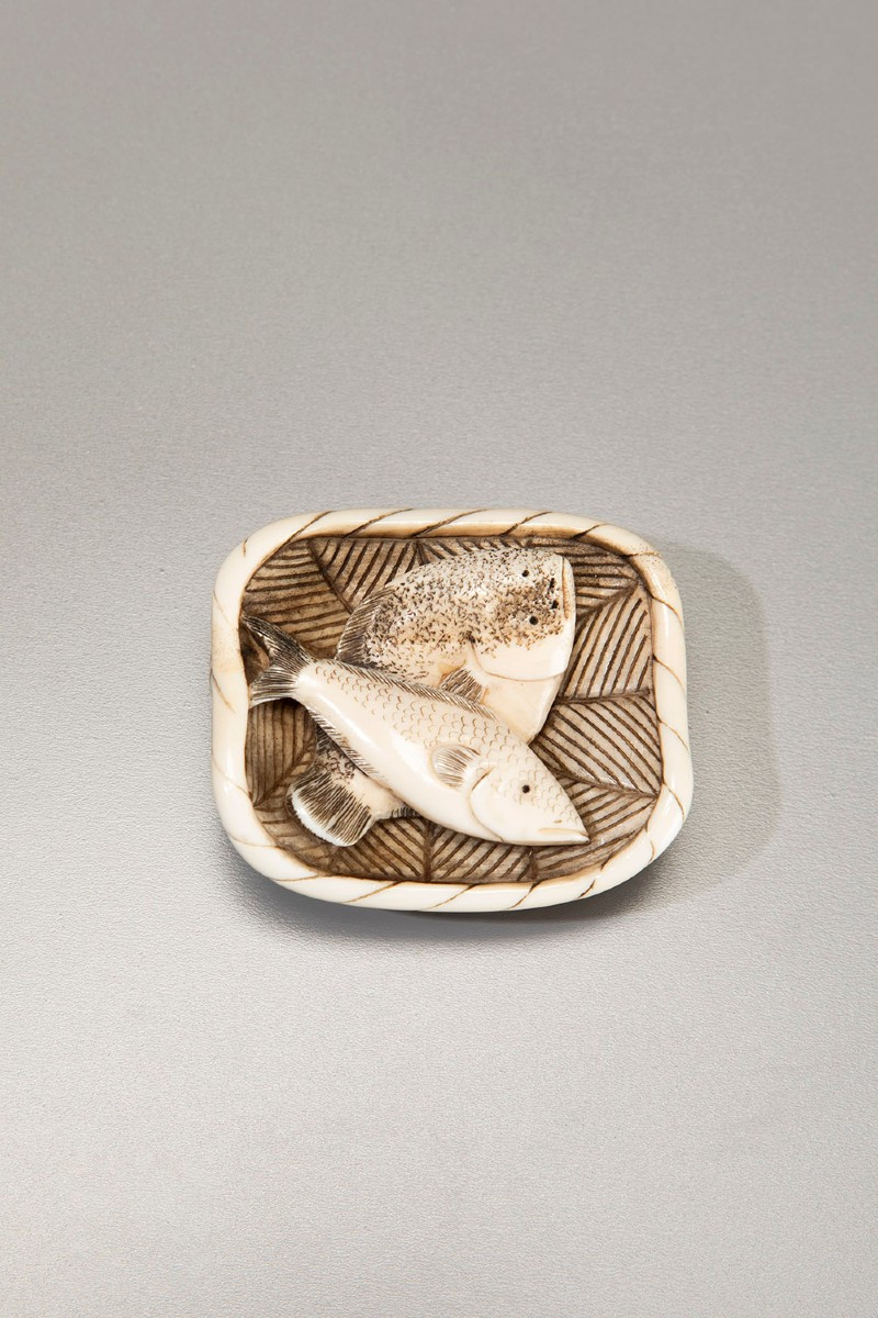 An Ivory Netsuke Depicting A Basket Of Fish