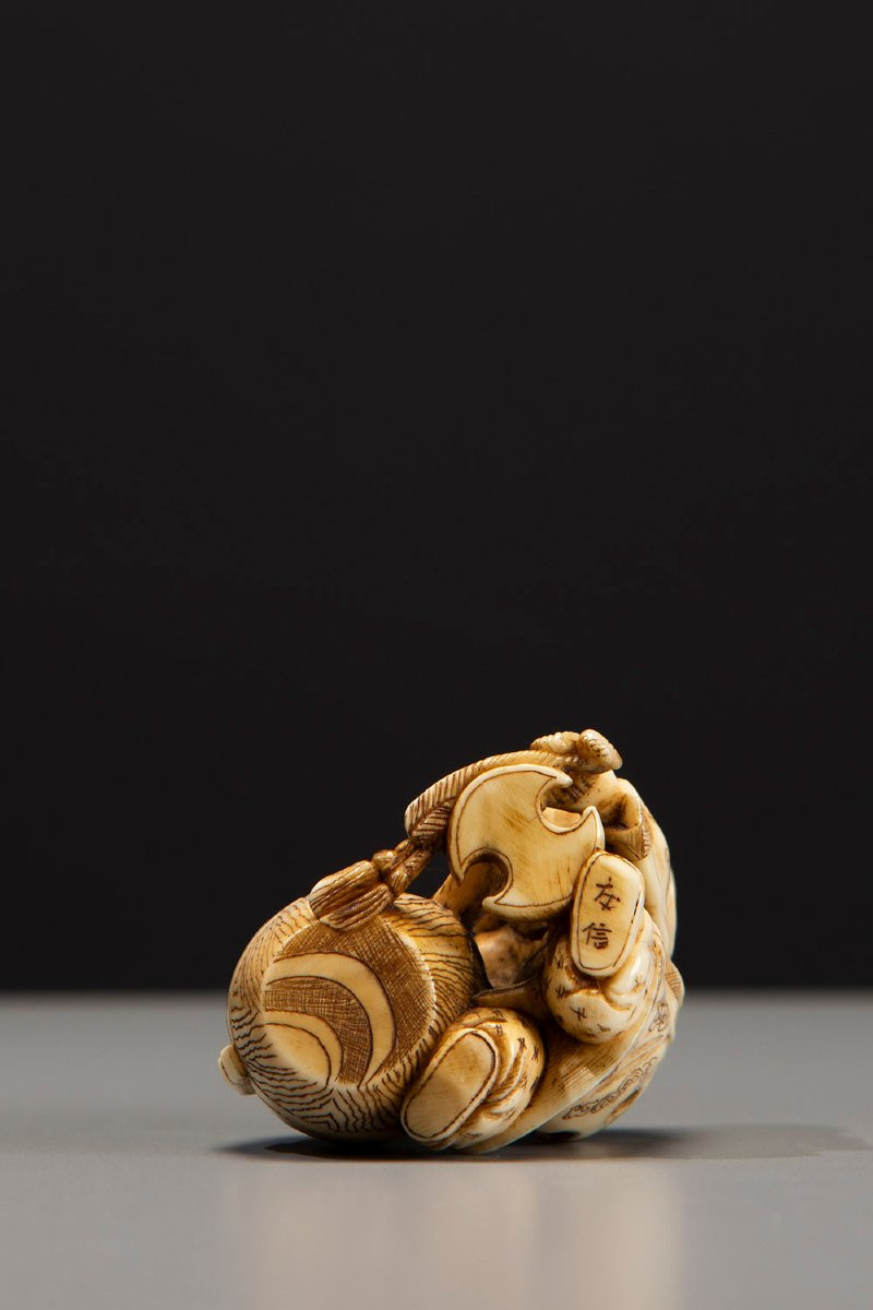Netsuke en ivoire représentant Daikoku avec son marteau caractéristique-photo-1