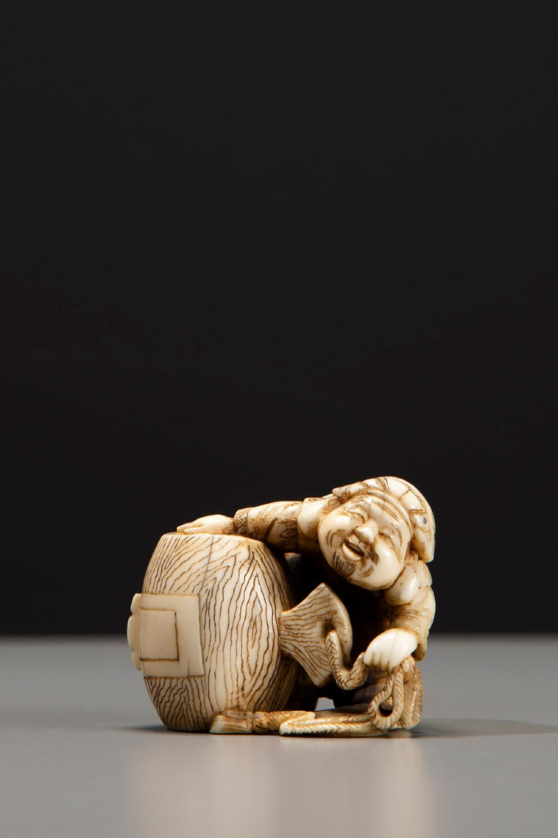 Netsuke en ivoire représentant Daikoku avec son marteau caractéristique