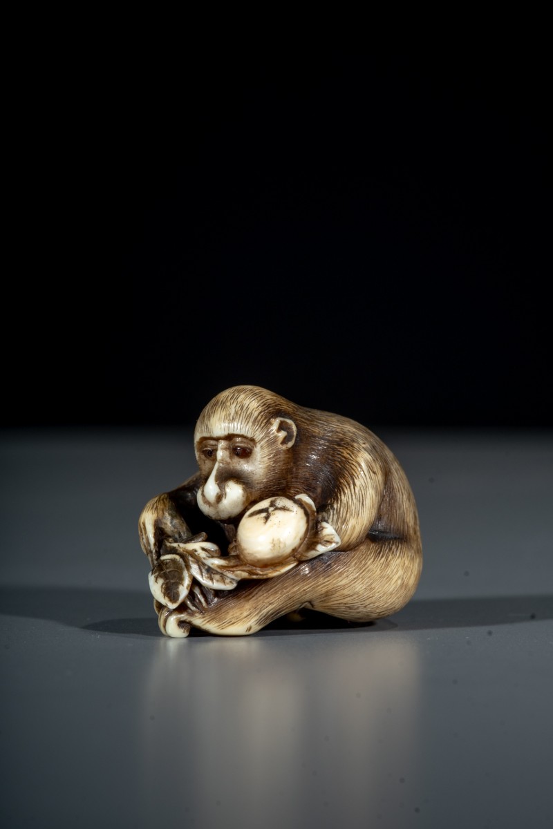 A Japanese Ivory Netsuke Of A Monkey With Fruit