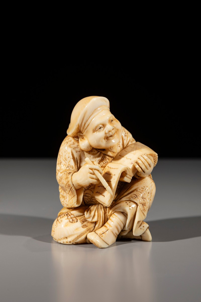 An Ivory Okimono Of Daikoku With Brush And Book