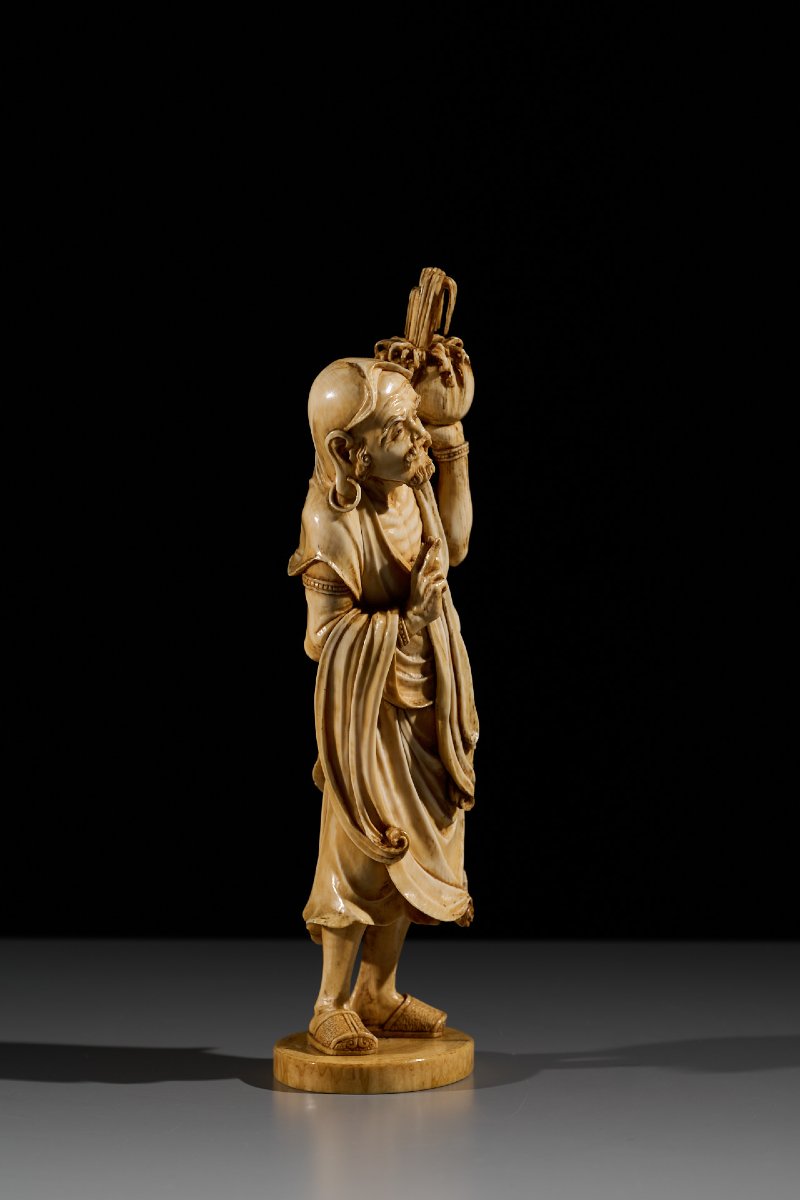 An Ivory Okimono Of A Rakan Holding A Ritual Vase, Signed Kazutoshi-photo-2