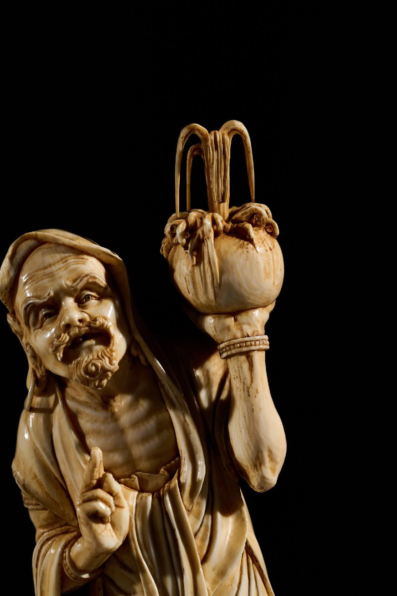 An Ivory Okimono Of A Rakan Holding A Ritual Vase, Signed Kazutoshi-photo-1