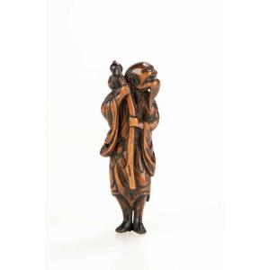 Netsuke en buis représentant un sennin avec une bouteille de saké