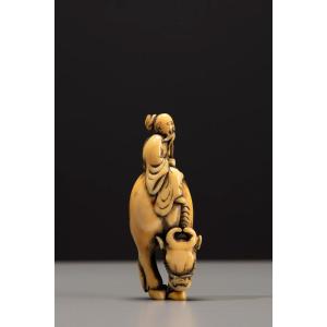 Netsuke en ivoire représentant Roshi assis sur le dos d’un buffle