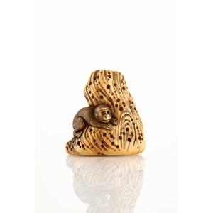 Netsuke en ivoire représentant un singe accroupi sur un rocher