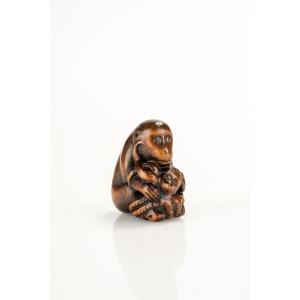 A Boxwood Netsuke Of A Monkey With An Octopus