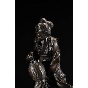 Okimono en bronze de l'École de Tokyo représentant une geisha en marche, signé Genryūsai Seiya 