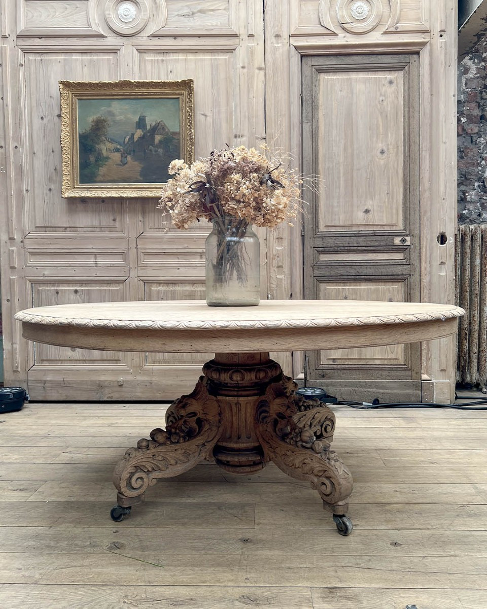 Table ovale en chêne sculpté sur piètement central à roulettes d’esprit Napoléon III